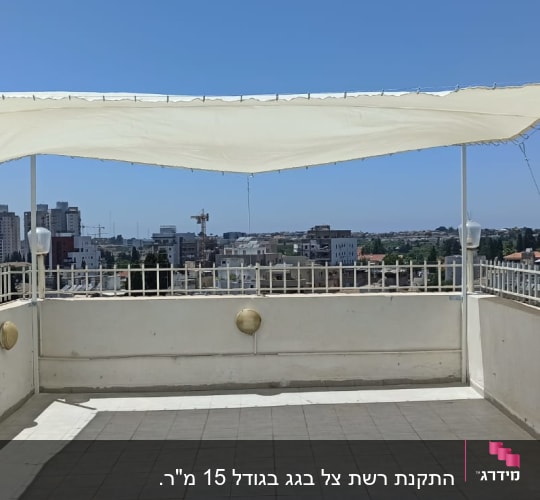סוכך בד לבן מתוח על עמודים במרפסת גג